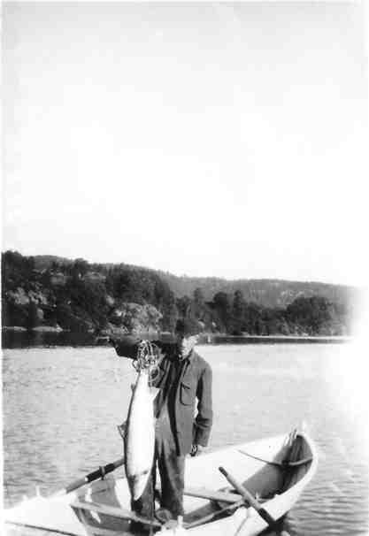 Olaf Jensen i rosjekta med nygått storlax fra tidlig på 1930-tallet. Egslandet ses i bakgrunnen. 
